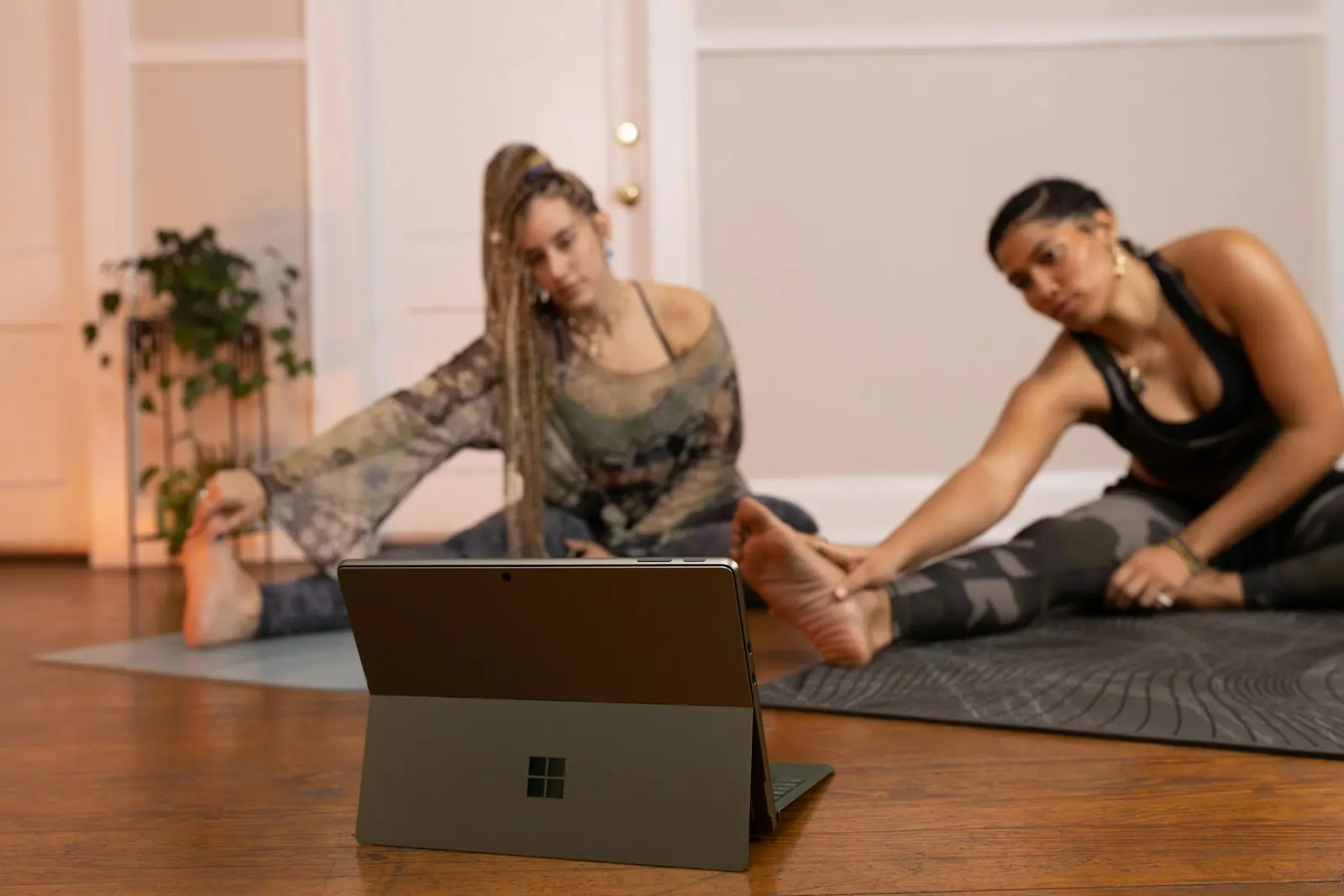 Two people training at home following a coach on a laptop